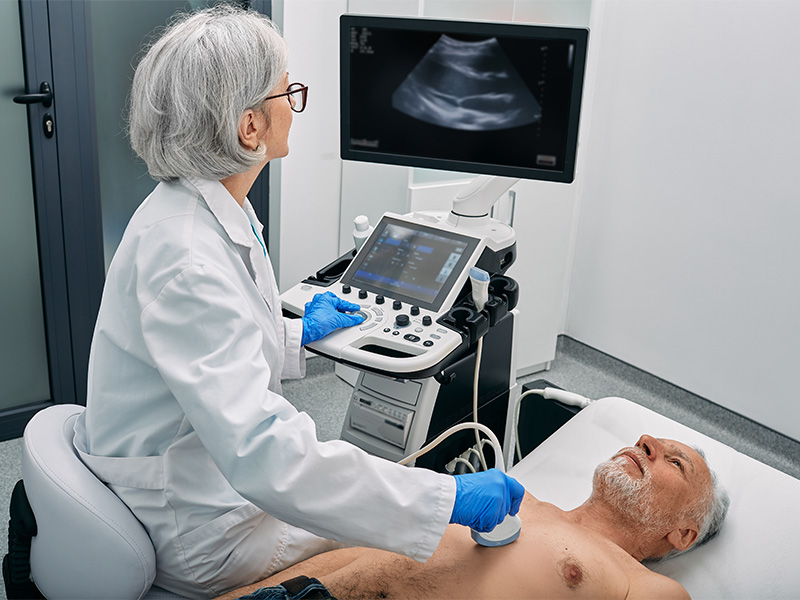 Senior wird bei einer Ultraschalluntersuchung des Herzens von einem Facharzt mit einem modernen Sonographiegerät untersucht.